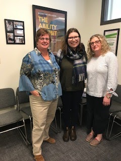 Lillian Liebanthal, Melissa Shafner, and Julia Kaback pose in from of a poster from the Ability Exhibit in the Accessibility Office!