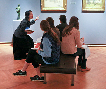 A first-year seminar class discusses a painting at the Lyman Allen Museum.