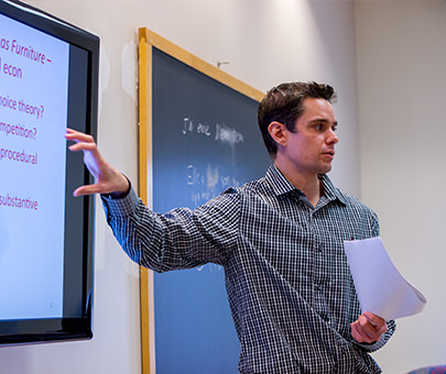 David Chavanne, assistant professor of economics, lectures the classroom.