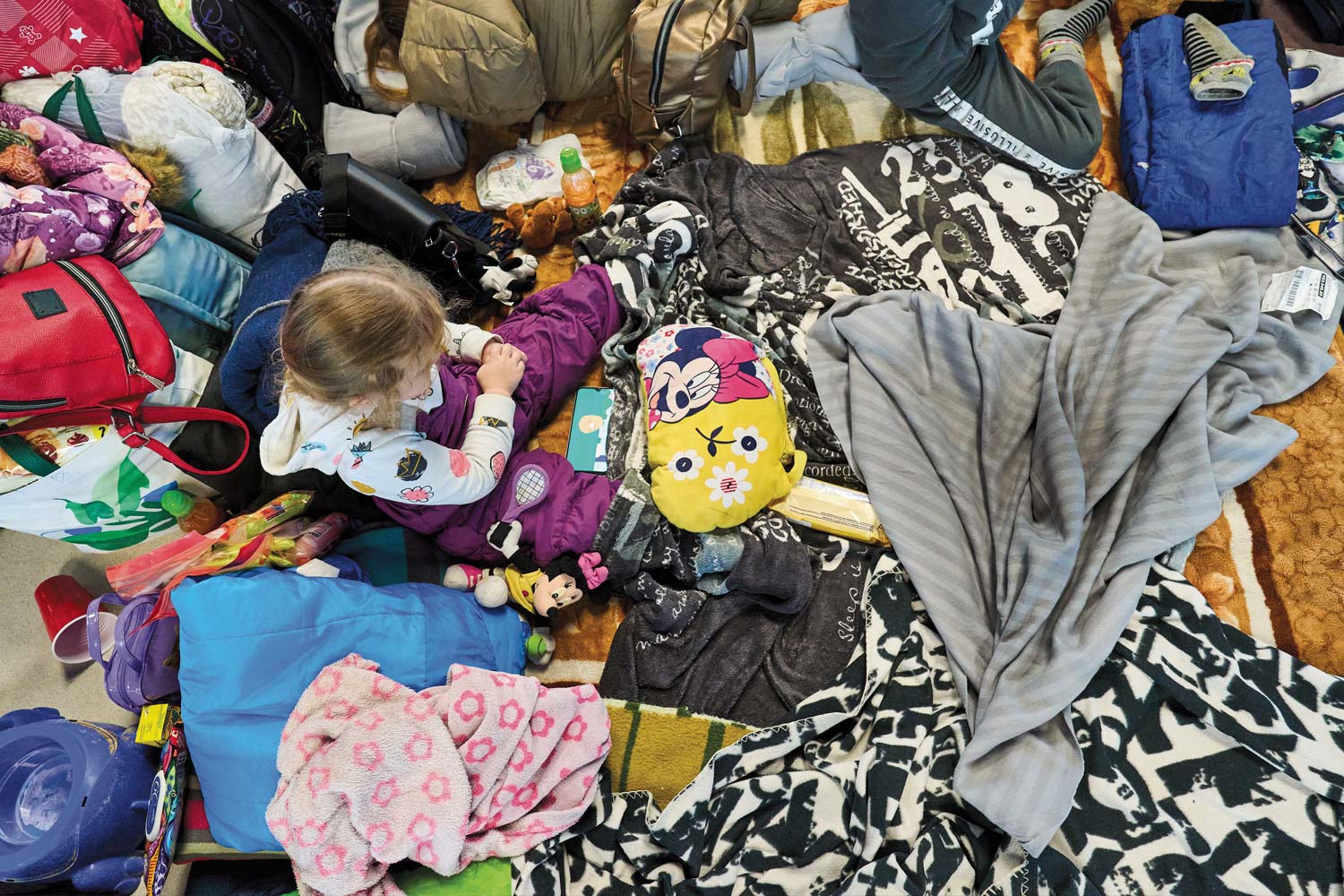 Image of young girl sitting among her scattered belongings