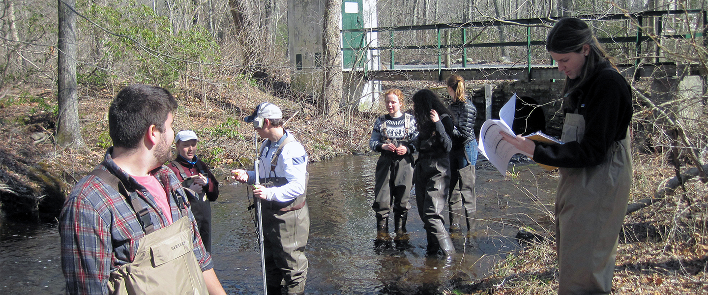 Students test water samples in a local river