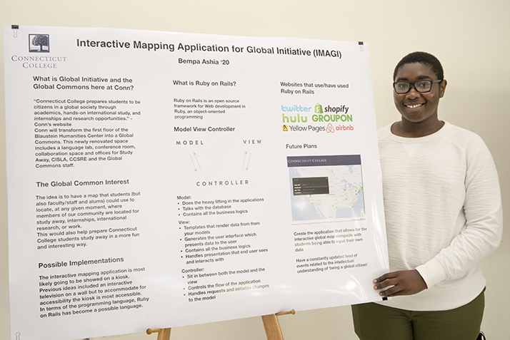 Bempa Ashia 20 stands next to a poster about his summer science research.