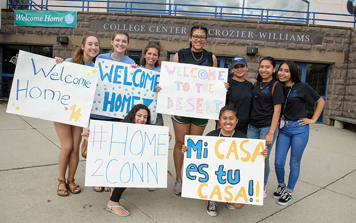 Sophomores, juniors and seniors cheer as new students arrive. 