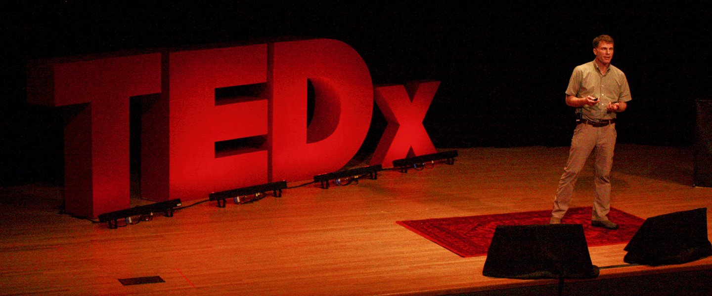 Professor Chad Jones speaks on stage at TEDxConnecticutCollege