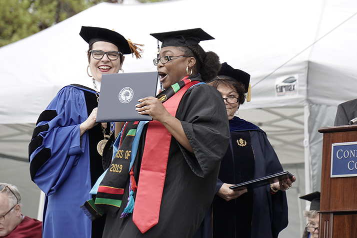 A graduate receives her diploma from President Katherine Bergeron