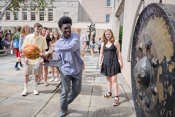 A new student rings the Castle Court gong. 