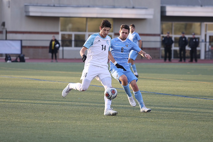 A Conn player and a Tufts player battle for the ball.