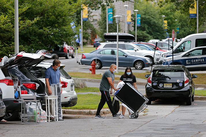Students and families move belongings into the dorms