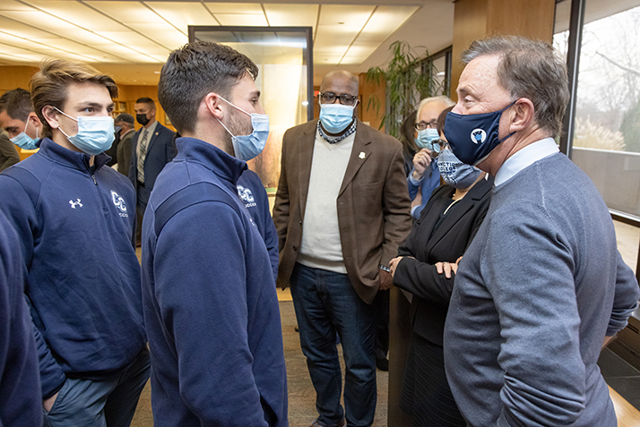 Governor Ned Lamont, right, speaks with members of the team while President Katherine Bergeron, her spouse Butch Rovan, and State Representatives Anthony Nolan look on. 