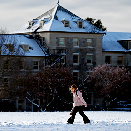 A student walks across a snowy Tempel Green.