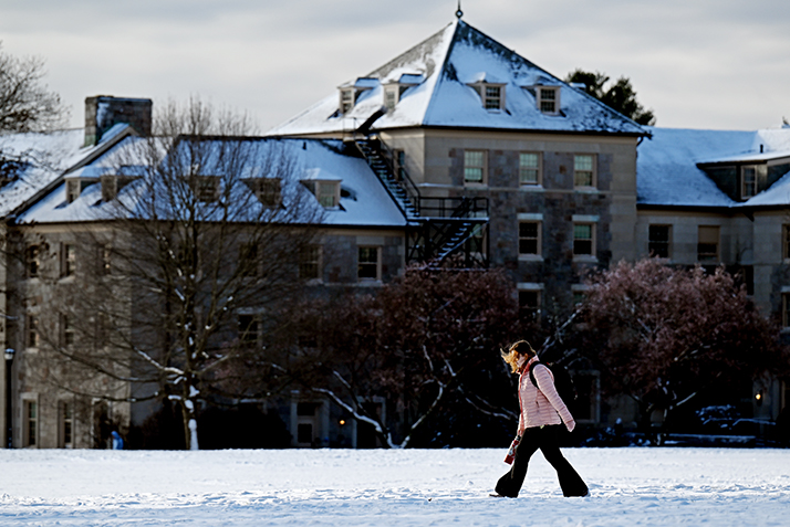 A student walks through the snowy campus.