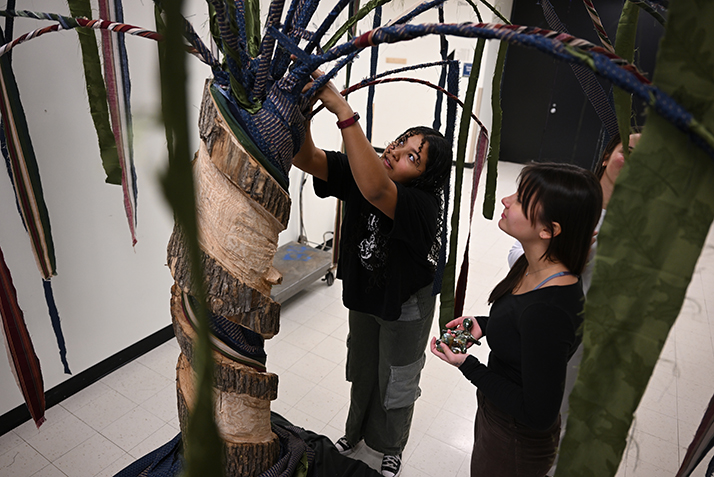 Alexa Booker ’24 puts the finishing touches on her sculpture “Trees and their People” with help from ART226 classmates Sophie George ’24 and Riley Griffith ’24 prior to the semester-end critique in Prof.