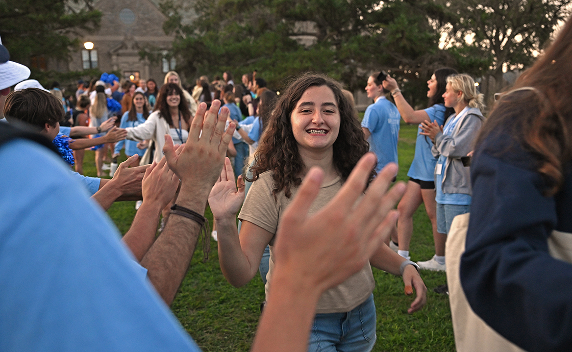 New students are welcomed with high fives and cheers.