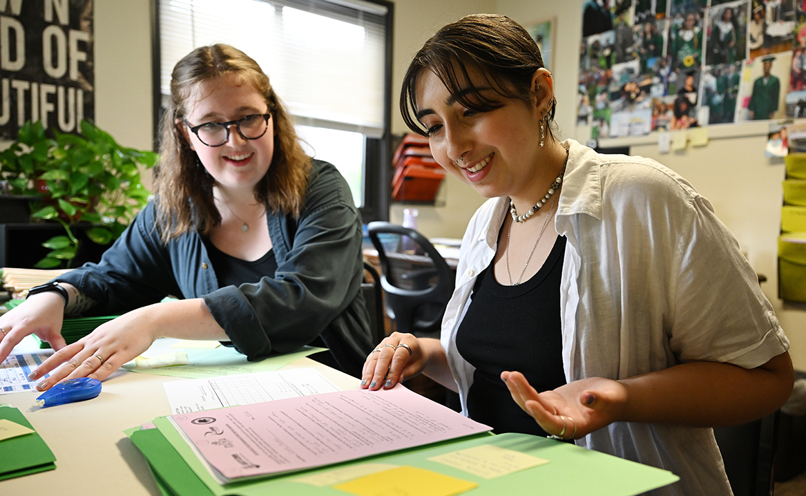 Civic Leaders Sarah Goodman Duffy ’26 and Leila Merhi ’25 review Teen Development and Employment Program applications at New London Youth Affairs, as they prepare to assemble orientation packets for summer employment youth.
