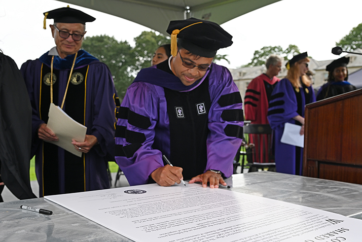 Board of Trustees Chair Debo Adegbile signs the shared governance covenant at Convocation.