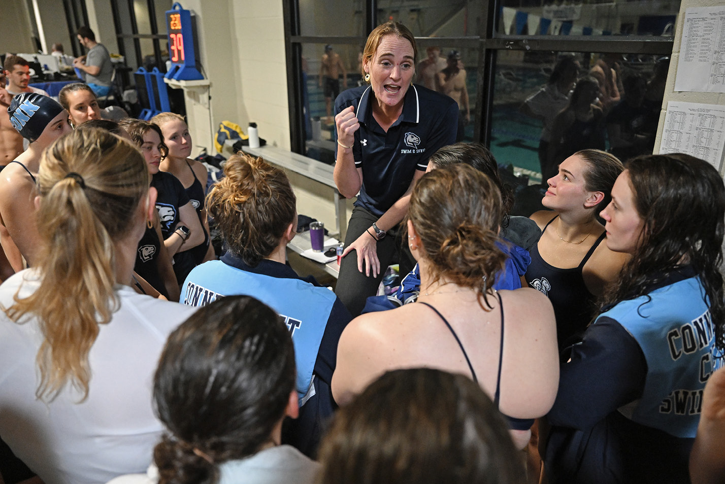 Women's swim coach talks with the team