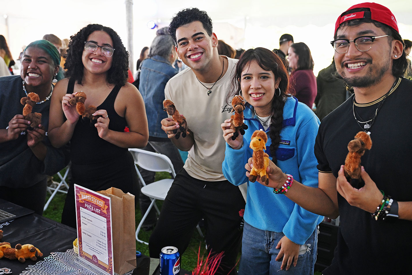 Students poses with toy camels at Harvestfest at Fall Weekend 2023
