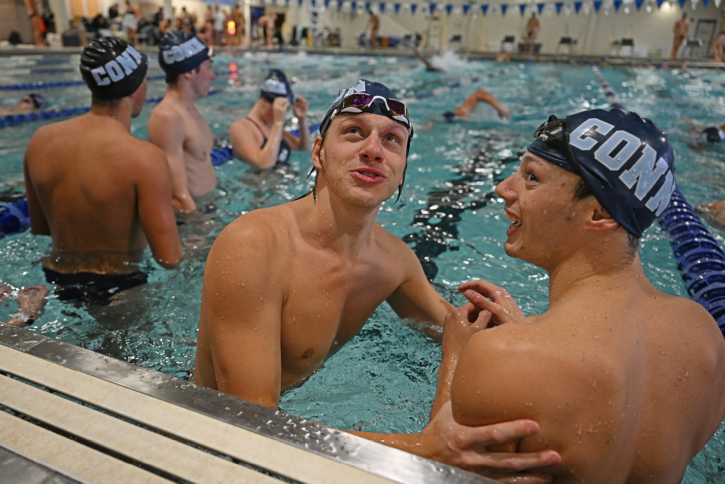 Male swimmers warming up in the pool before a meet.