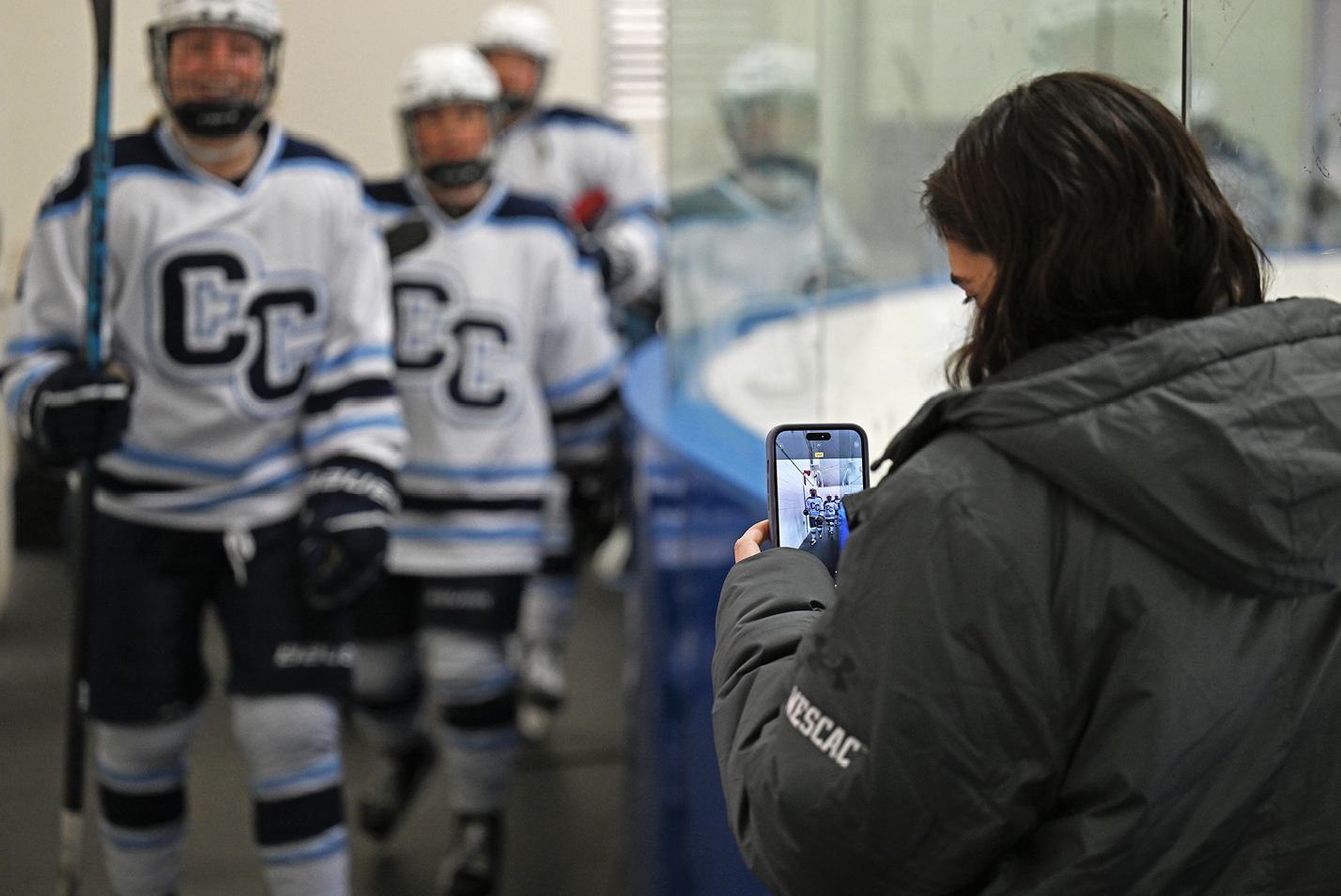 A student snaps a camera image of the hockey team.