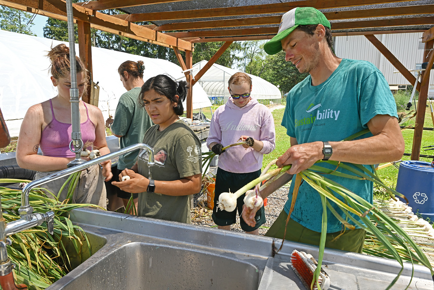 Student workers wash vegetables in the the Sprout garden