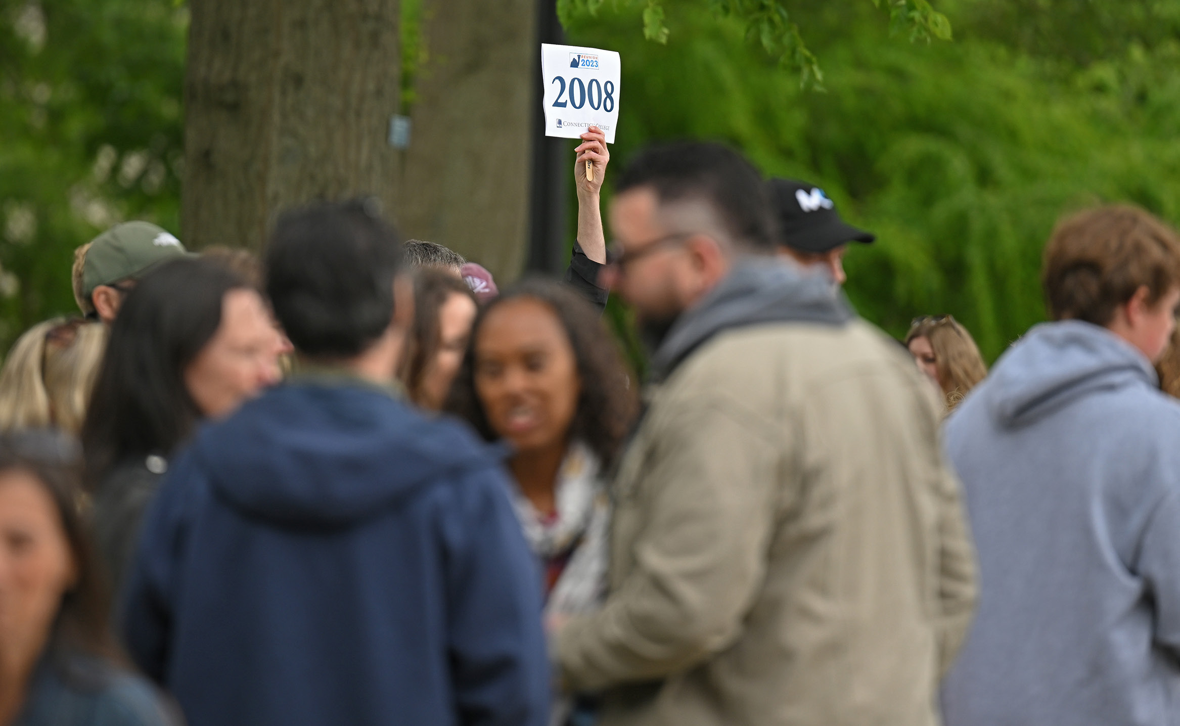 A volunteer holds up a sign at the alumni parade during Reunion 2023.