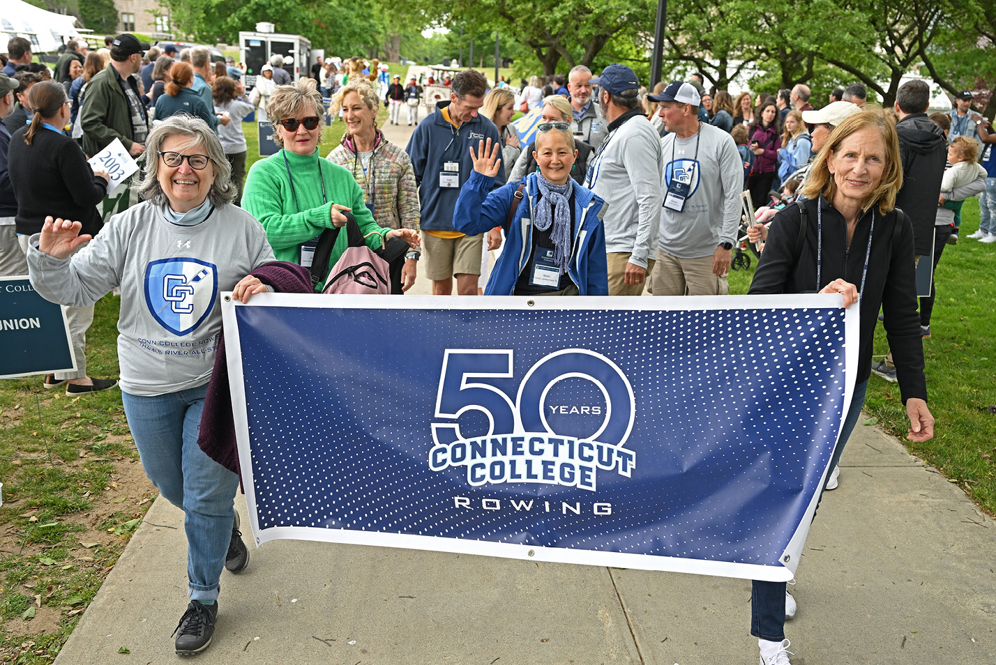 Alums hold a 50th Rowing Reunion banner during the Reunion parade.