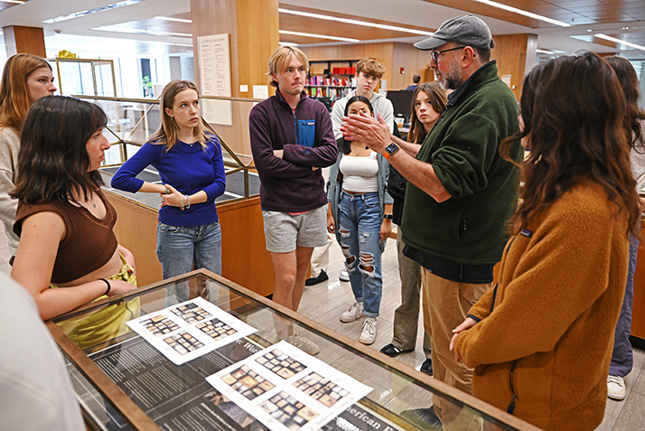 Christopher B. Steiner, the Lucy C. McDannel '22 Professor of Art History & Anthropology and director of the Museum Studies Certificate Program, works with the students as they install an exhibit of photography from the late 19th and early 20th centuries in Shain Library..