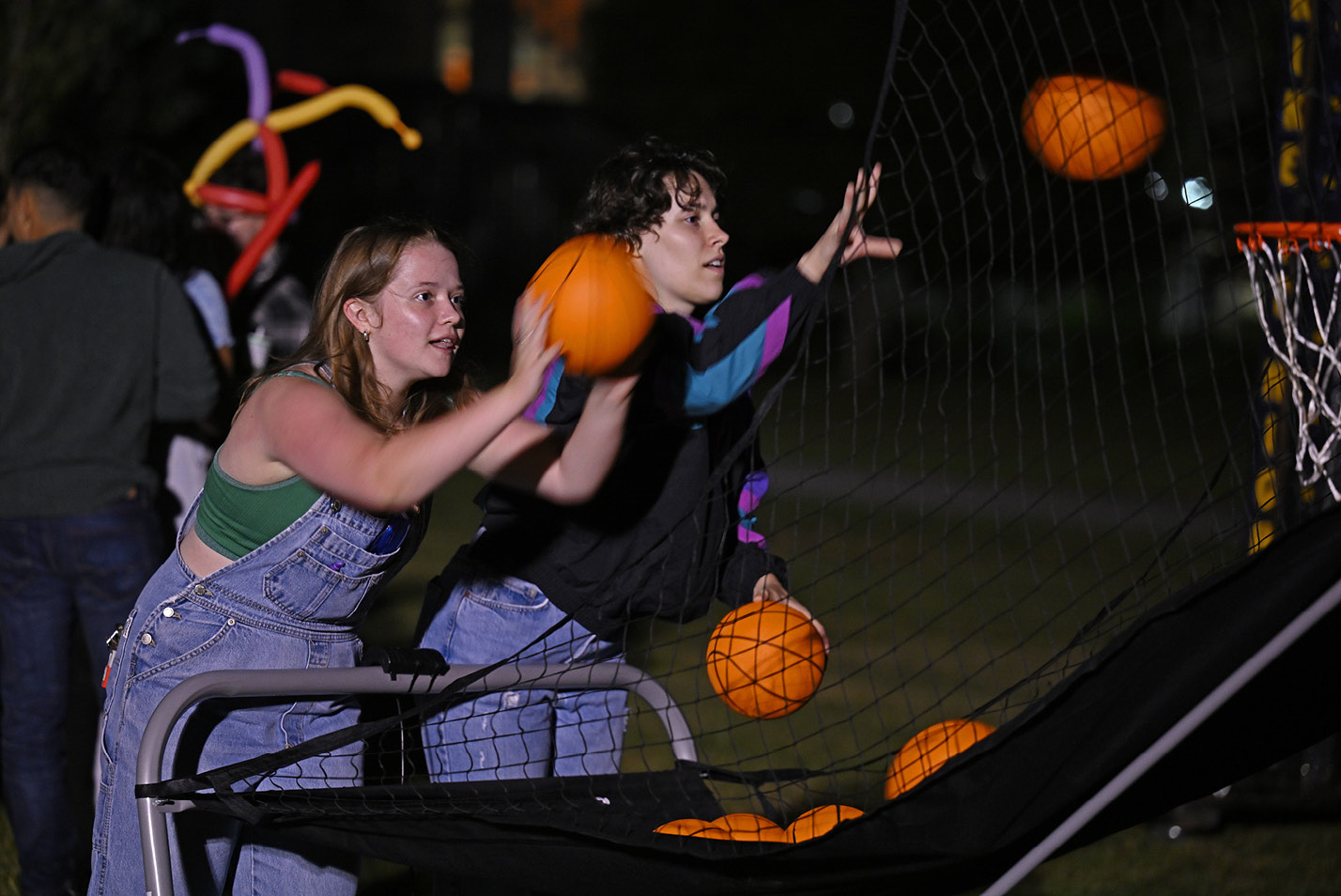 Students shoot basketballs on the midway at Fall carnival