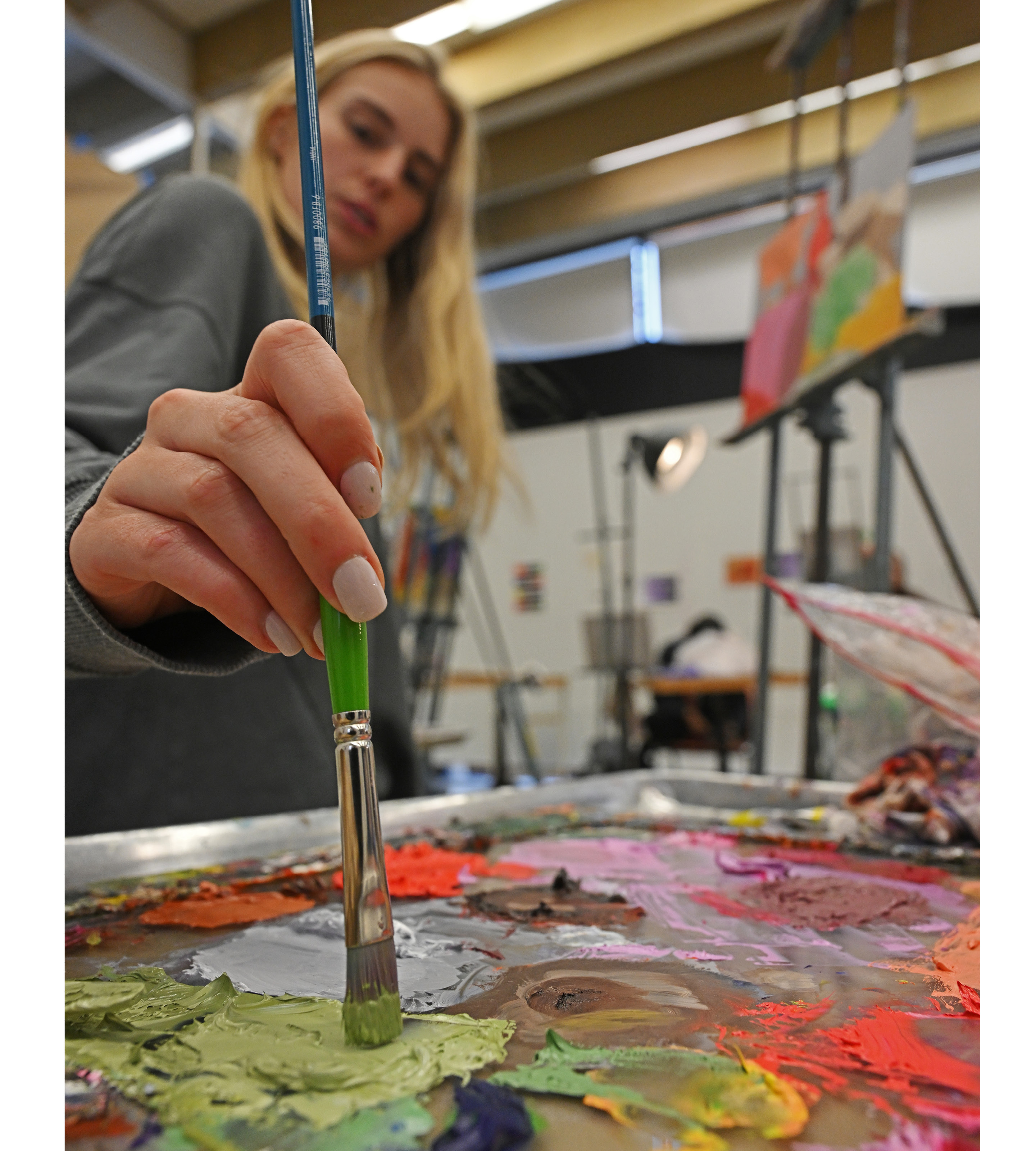 Student mixing paint colors