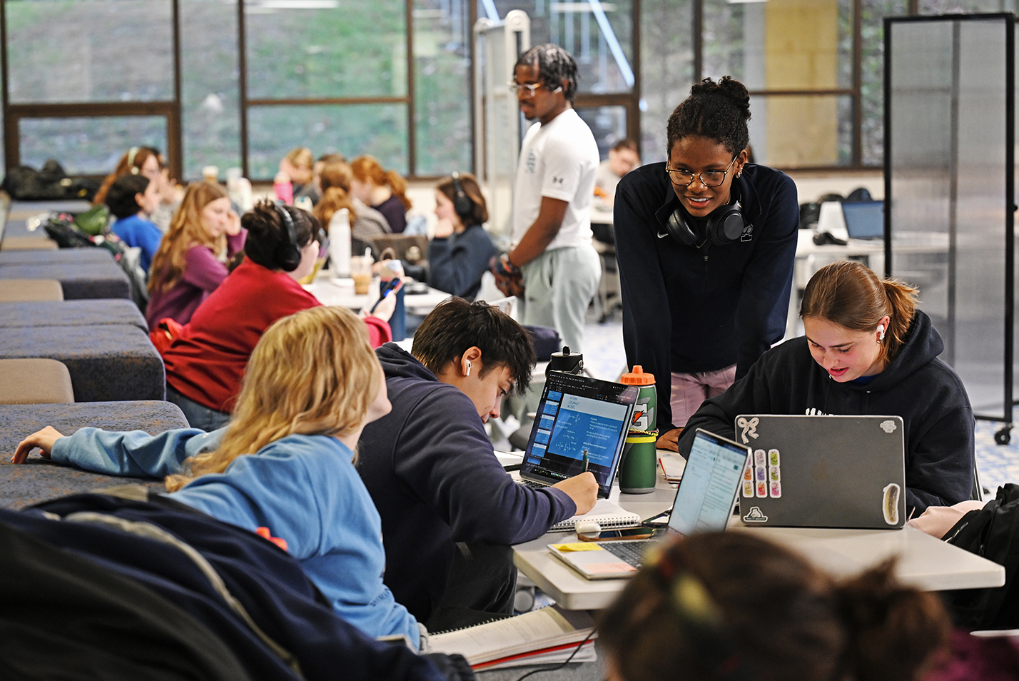 Students work around a row of tables as they study for finals.