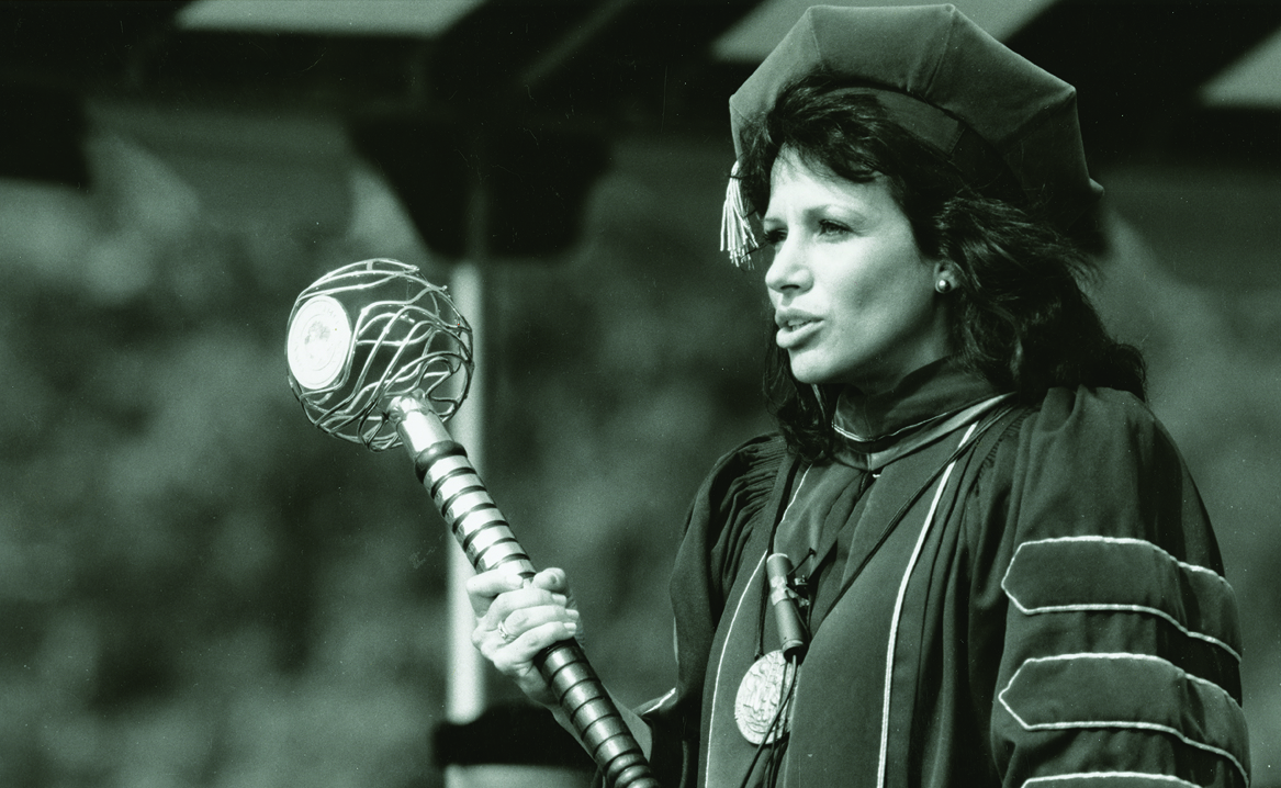 An archival portrait of Former President Claire Gaudiani holding the College Mace.