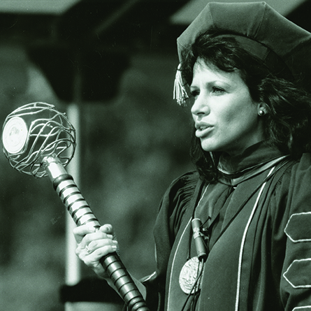 An archival portrait of Former President Claire Gaudiani holding the College Mace.