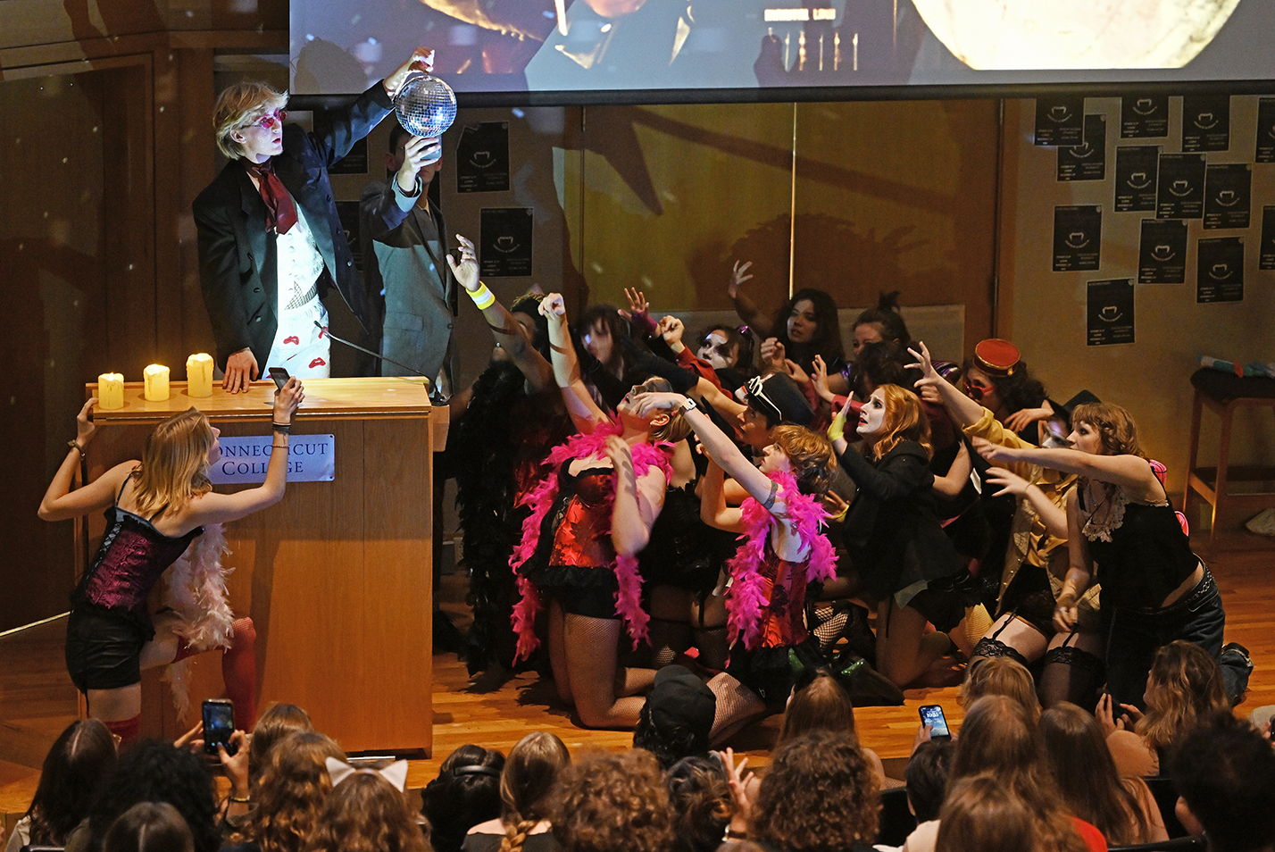 The cast of a student performance of the Rocky Horror Picture Show perform on stage.