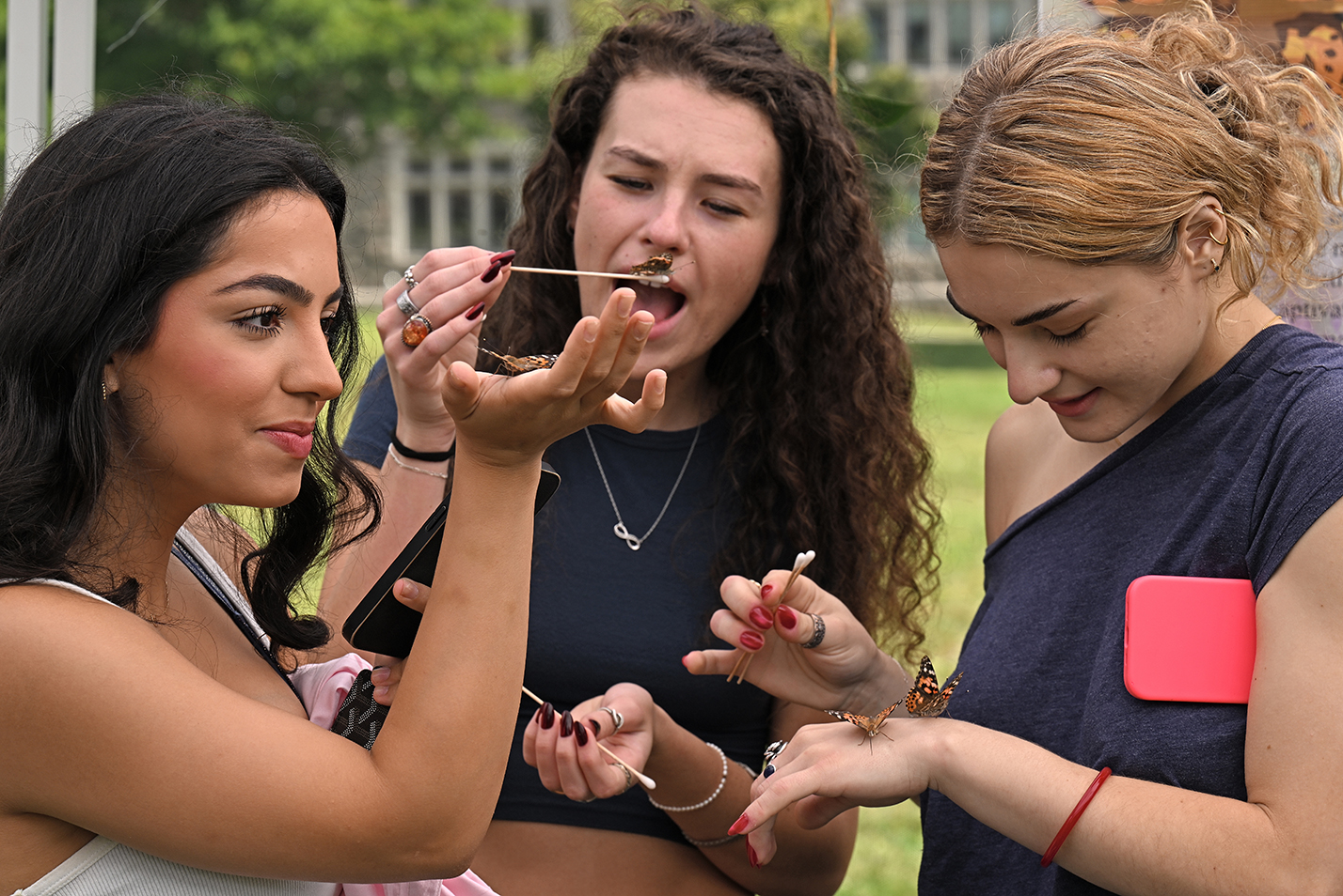 three students react differently to getting up close with butterflies