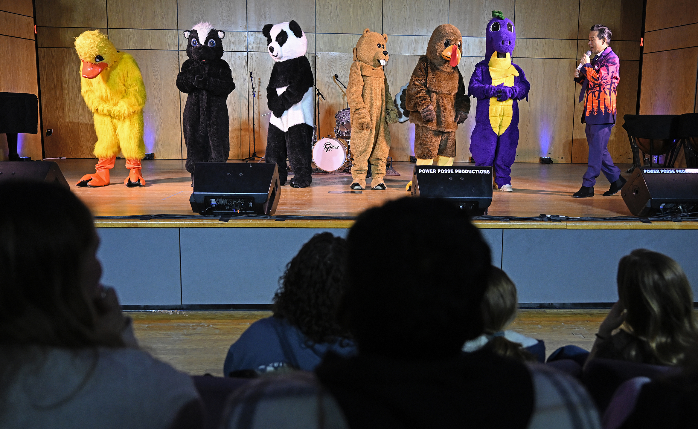 Students in mascot costumes take to the stage for a singing competition.