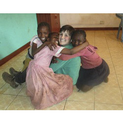 Gabby Arenge '14 poses with children in Kibera.